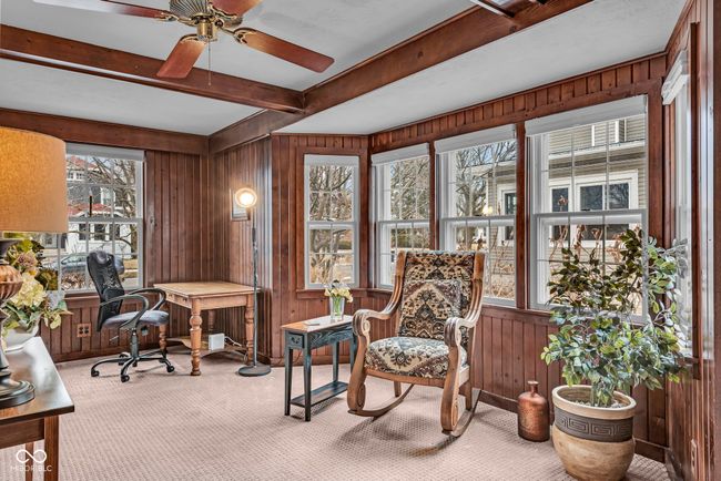carpeted office featuring beam ceiling, wooden walls, and ceiling fan | Image 4