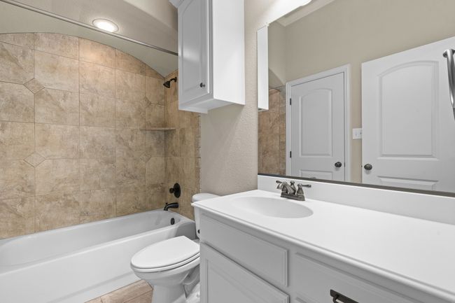 Hall Bathroom with vanity, bathtub / shower combination, and tile patterned flooring. Opens into third bedroom | Image 25