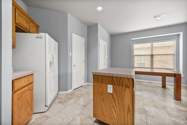 Kitchen with white fridge with ice dispenser, a center island, and recessed lighting | Image 7
