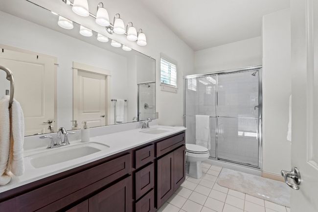 The primary bathroom has a walk-in shower, dual-sink vanity, and large walk-in closet. | Image 30