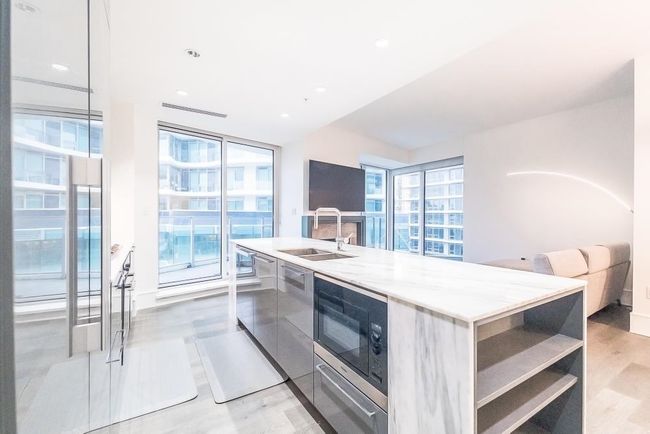 Kitchen featuring a sink, built in microwave, plenty of natural light, light wood-style floors, and modern cabinets | Image 11