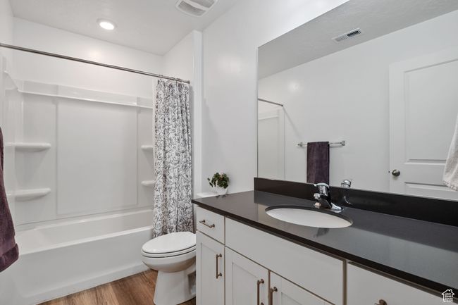 Bathroom with wood finished floors, visible vents, vanity, and toilet | Image 13