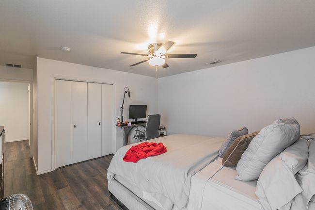 Unit 4900 Primary Bedroom featuring dark wood-type flooring, ceiling fan, and a closet | Image 13