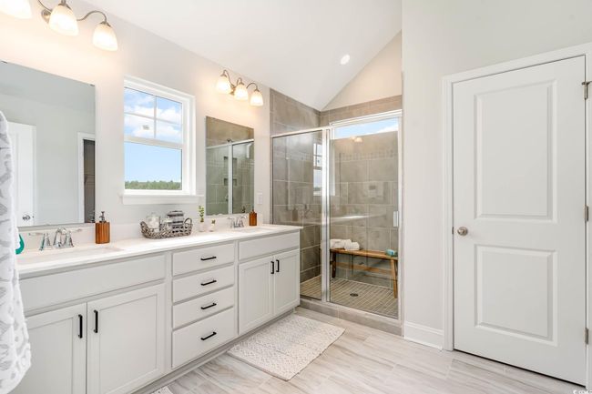 Bathroom with double vanity, a stall shower, lofted ceiling, and recessed lighting | Image 19