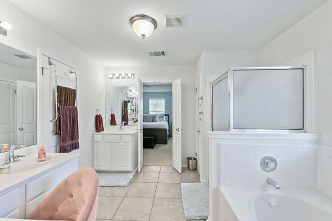 Ensuite bathroom with vanity, a garden tub, a shower stall, and tile patterned flooring | Image 20