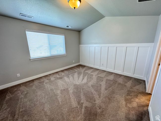 Additional living space featuring visible vents, carpet flooring, and vaulted ceiling | Image 11