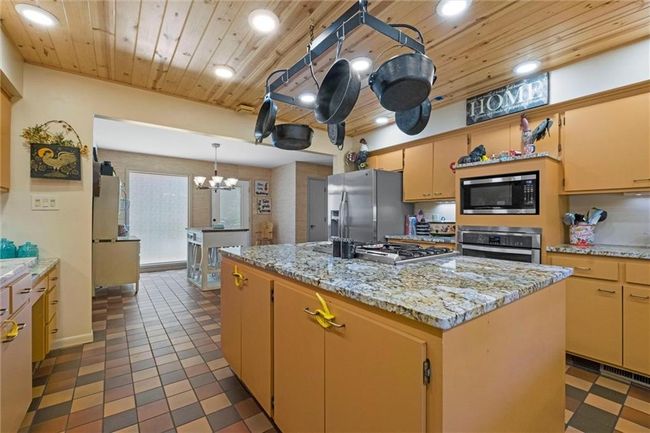 Kitchen with appliances with stainless steel finishes, wooden ceiling, a chandelier, a center island, and recessed lighting | Image 9