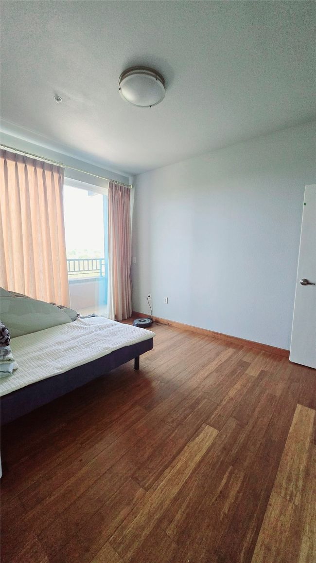 Bedroom with wood finished floors and a textured ceiling | Image 7
