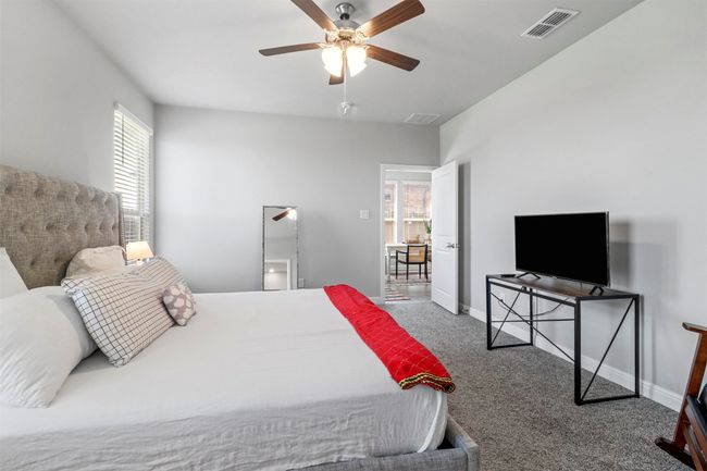 Bedroom featuring multiple windows, carpet flooring, and ceiling fan | Image 9