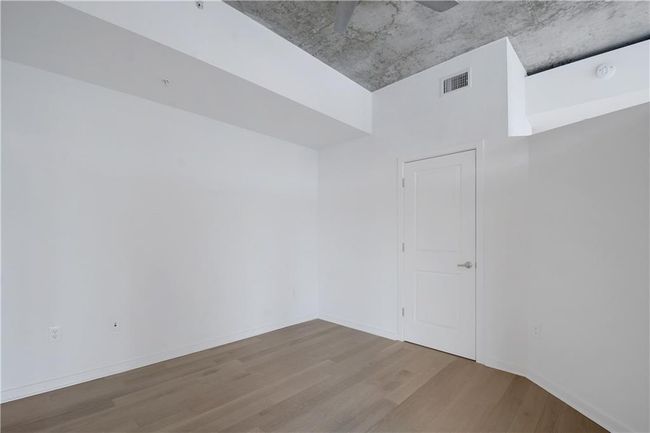 Empty room with baseboards, visible vents, wood finished floors, and ceiling fan | Image 12