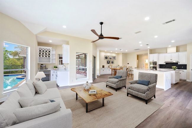 View of den with windows looking onto pool. | Image 10