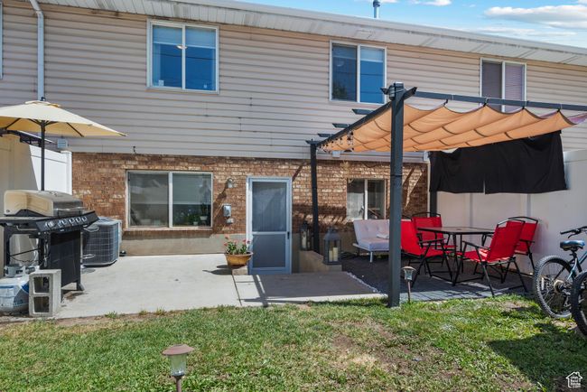 Rear view of property with a pergola, a yard, brick siding, and a patio | Image 24