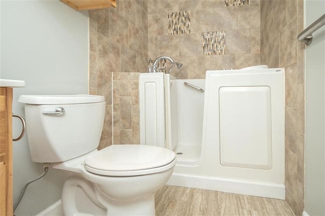 Full bath with vanity, toilet, radiator, and wood finished floors | Image 30
