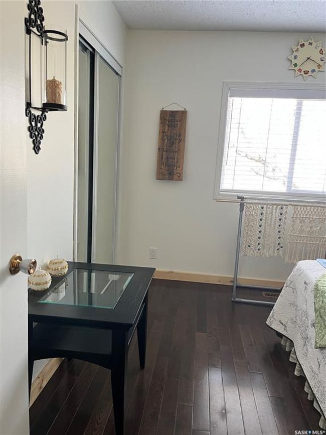 Bedroom with dark wood-style floors, a closet, and baseboards | Image 34