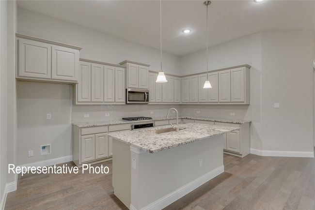 Kitchen with appliances with stainless steel finishes, light wood finished floors, pendant lighting, an island with sink, and recessed lighting | Image 4