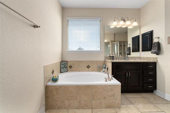 Bathroom featuring tile patterned floors, vanity, a stall shower, and a bath | Image 18