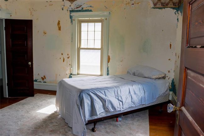 A Bedroom, with wooden floors, and some wallpaper removed | Image 27