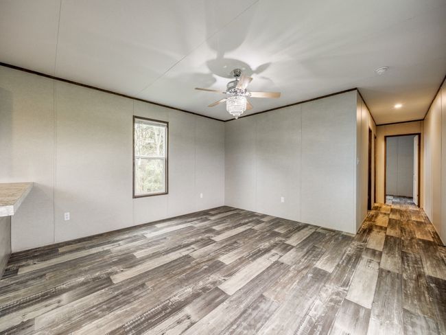 Empty room featuring ceiling fan, wood finished floors, and ornamental molding | Image 4