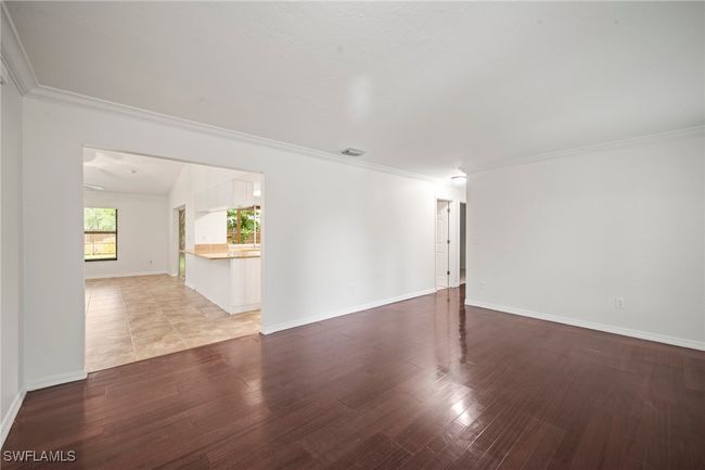 Empty room featuring light wood-style flooring and crown molding | Image 7