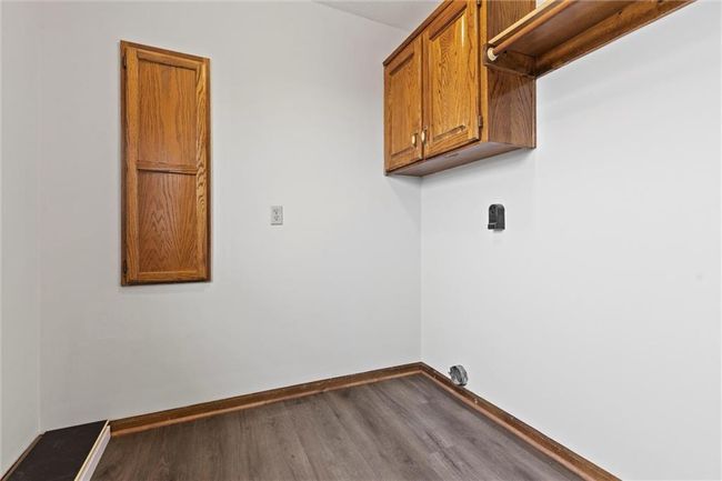Washroom with hardwood / wood-style floors and cabinets | Image 19