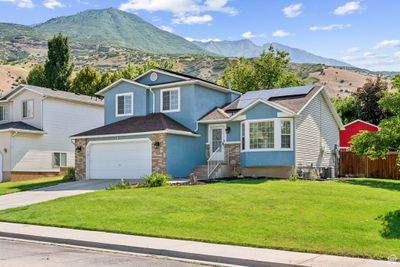 View of front facade featuring solar panels, a garage, and a front lawn | Image 2