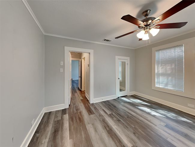 Spare room featuring ornamental molding, baseboards, wood finished floors, and a ceiling fan | Image 10