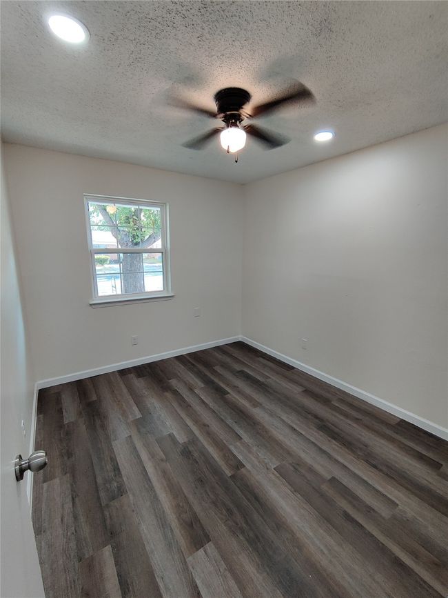 Spare room with a textured ceiling, ceiling fan, and hardwood / wood-style flooring | Image 9