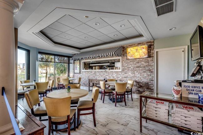 Dining area with a tray ceiling and brick wall | Image 32