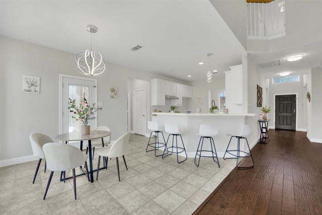 Dining room with a chandelier and light wood-style flooring | Image 15