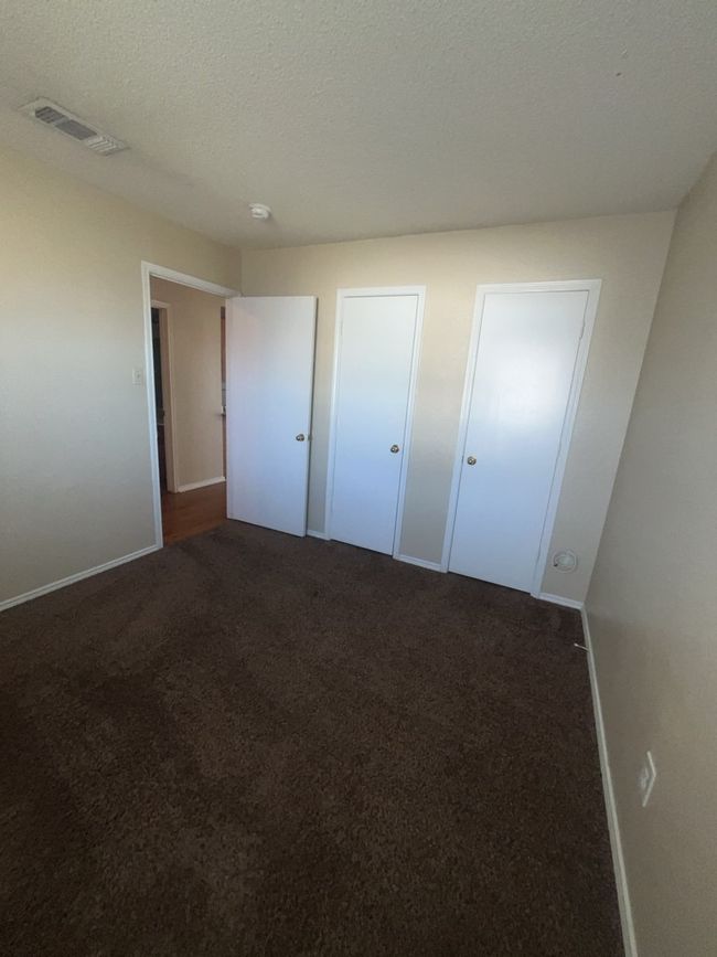 Unfurnished bedroom with baseboards, visible vents, carpet, and a textured ceiling | Image 10