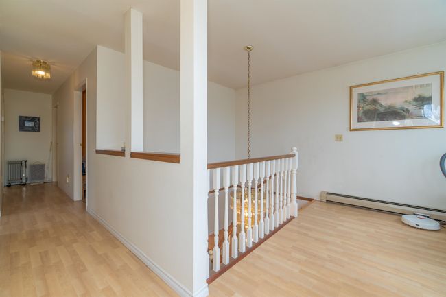 Corridor featuring light wood-type flooring, radiator, a baseboard radiator, and baseboards | Image 22