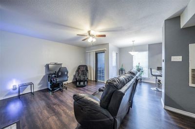 Living room featuring dark hardwood / wood-style flooring, ceiling fan, and a textured ceiling | Image 2