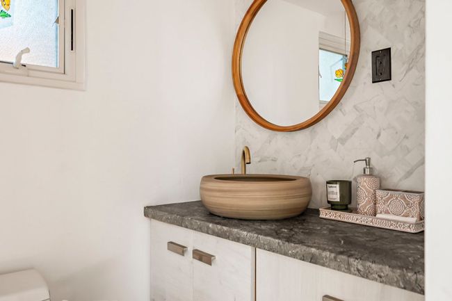 Half bathroom featuring decorative backsplash, toilet, and vanity | Image 30