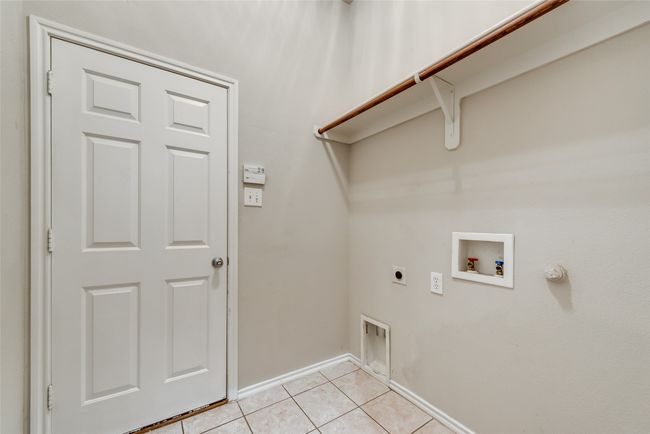 Laundry room featuring hookup for an electric dryer, washer hookup, light tile patterned floors, and gas dryer hookup | Image 24