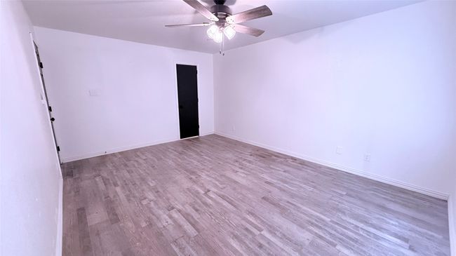 Empty room featuring wood finished floors, a ceiling fan, and baseboards | Image 11