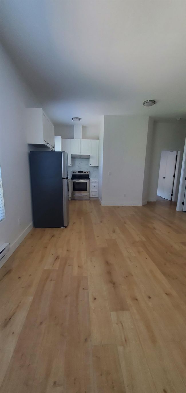 Unfurnished living room with baseboards and light wood finished floors | Image 18