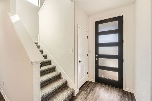 Entrance foyer featuring stairs, baseboards, and dark wood-style flooring | Image 4