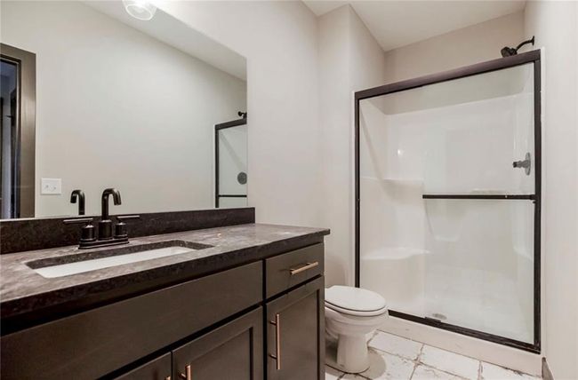 Full bathroom with a shower stall, vanity, and toilet | Image 24