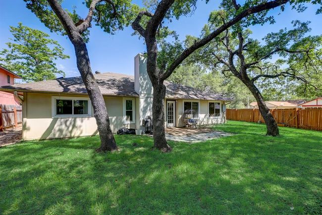 Back of property with a patio area, a chimney, and stucco siding | Image 13