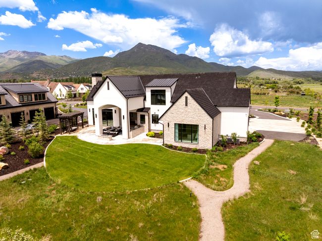 Rear view of property with a mountain view, a chimney, a yard, and a patio area | Image 58