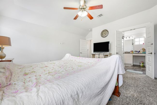 Bedroom featuring lofted ceiling, ceiling fan, and connected bathroom | Image 19