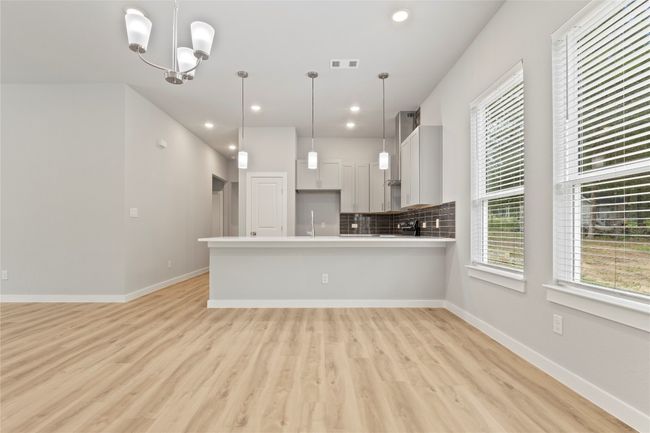 A stunning open floor plan, seamlessly blending the dining area and kitchen, bathed in beautiful light. | Image 11