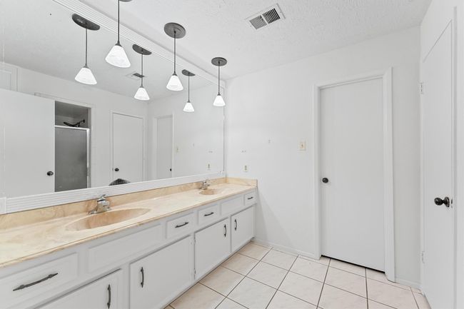 Bright primary bath with double sinks, modern fixtures, and abundant natural light. | Image 15