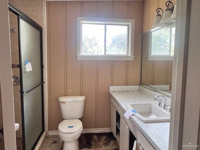 Bathroom featuring a decorative wall, vanity, and a stall shower | Image 14