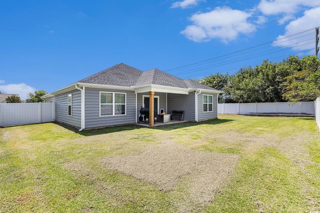 Back of house with a fenced backyard, roof with shingles, and a patio area | Image 31