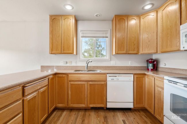 Kitchen featuring white appliances, light countertops, light wood-style floors, light brown cabinets, and recessed lighting | Image 13