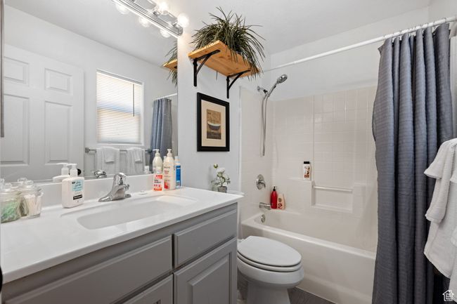 Bathroom with toilet, shower / bath combo with shower curtain, and vanity | Image 18