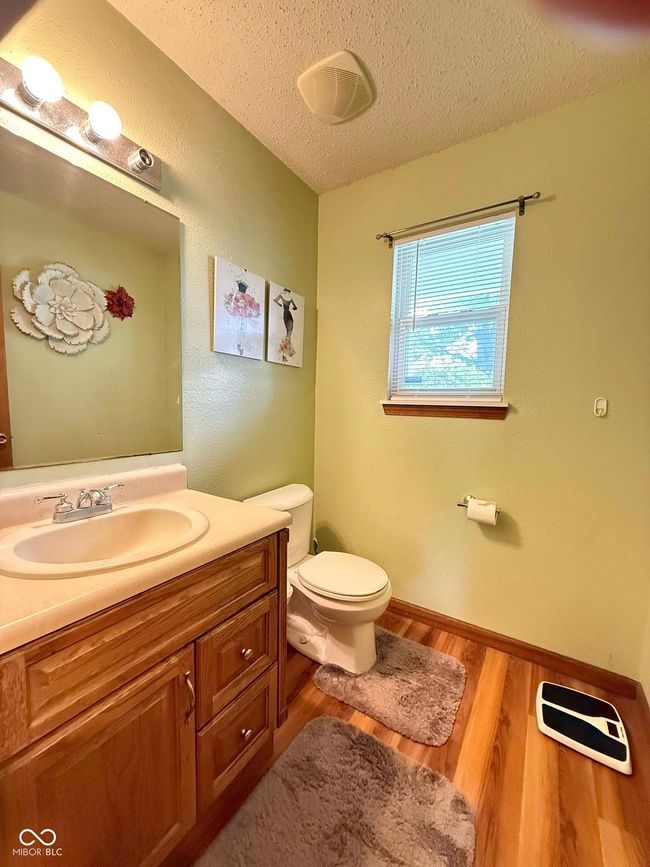 bathroom featuring a textured ceiling, wood finished floors, and vanity | Image 13