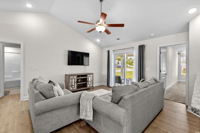 Living room with ceiling fan, high vaulted ceiling, baseboards, wood finished floors, and recessed lighting | Image 15