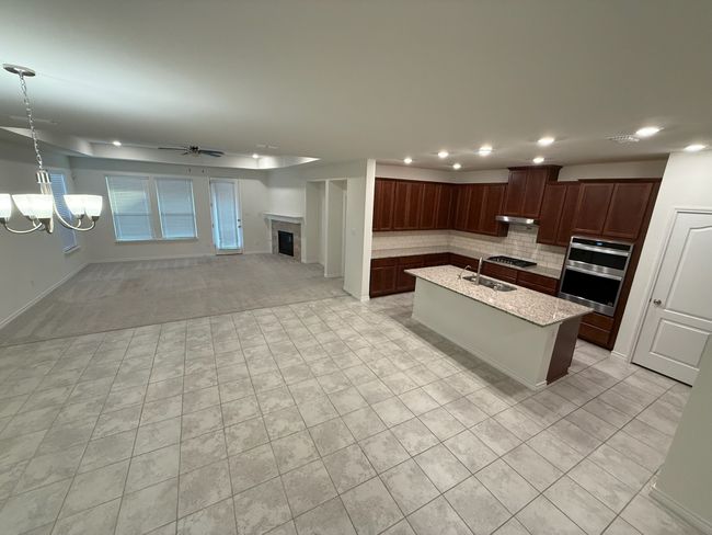 Kitchen featuring backsplash, a ceiling fan, a sink, under cabinet range hood, and recessed lighting | Image 7